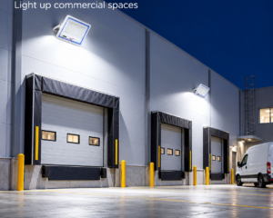 REALBUY 100W LED lens flood lights illuminating a warehouse loading area at night